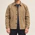 Front view of the khaki four-pocket chore coat worn over a navy shirt