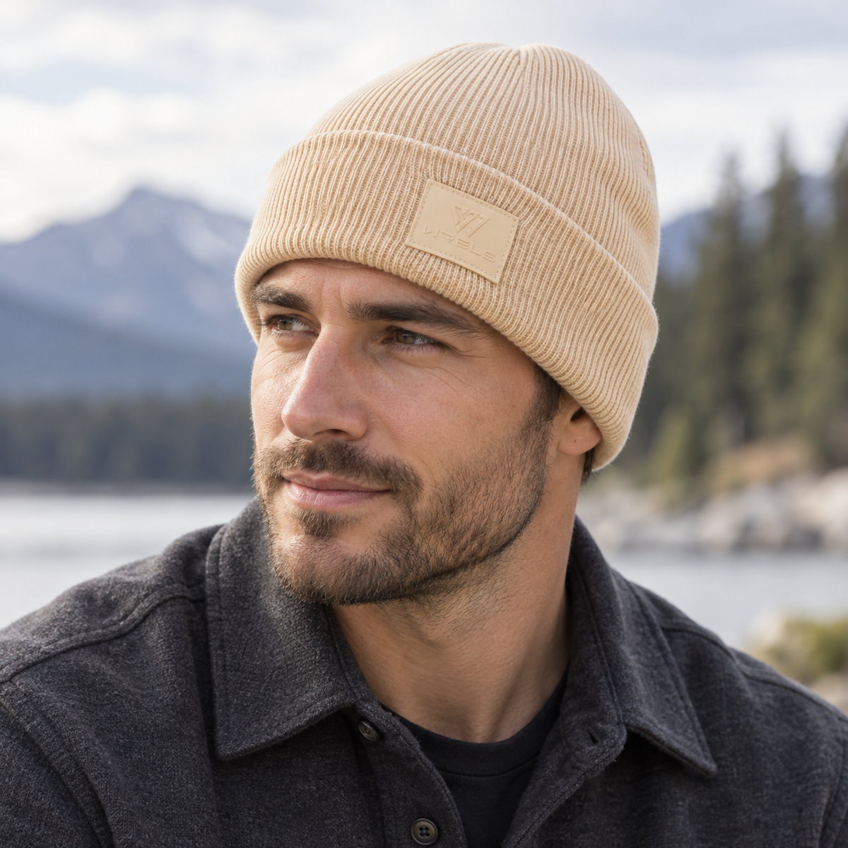 WRELS beige rib-knit beanie worn with its folded cuff and tonal logo patch