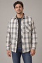 Man wearing the Ridgepine gray and taupe plaid shirt open over a charcoal tee