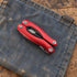 One folded red AceCamp multi tool resting on a canvas work surface