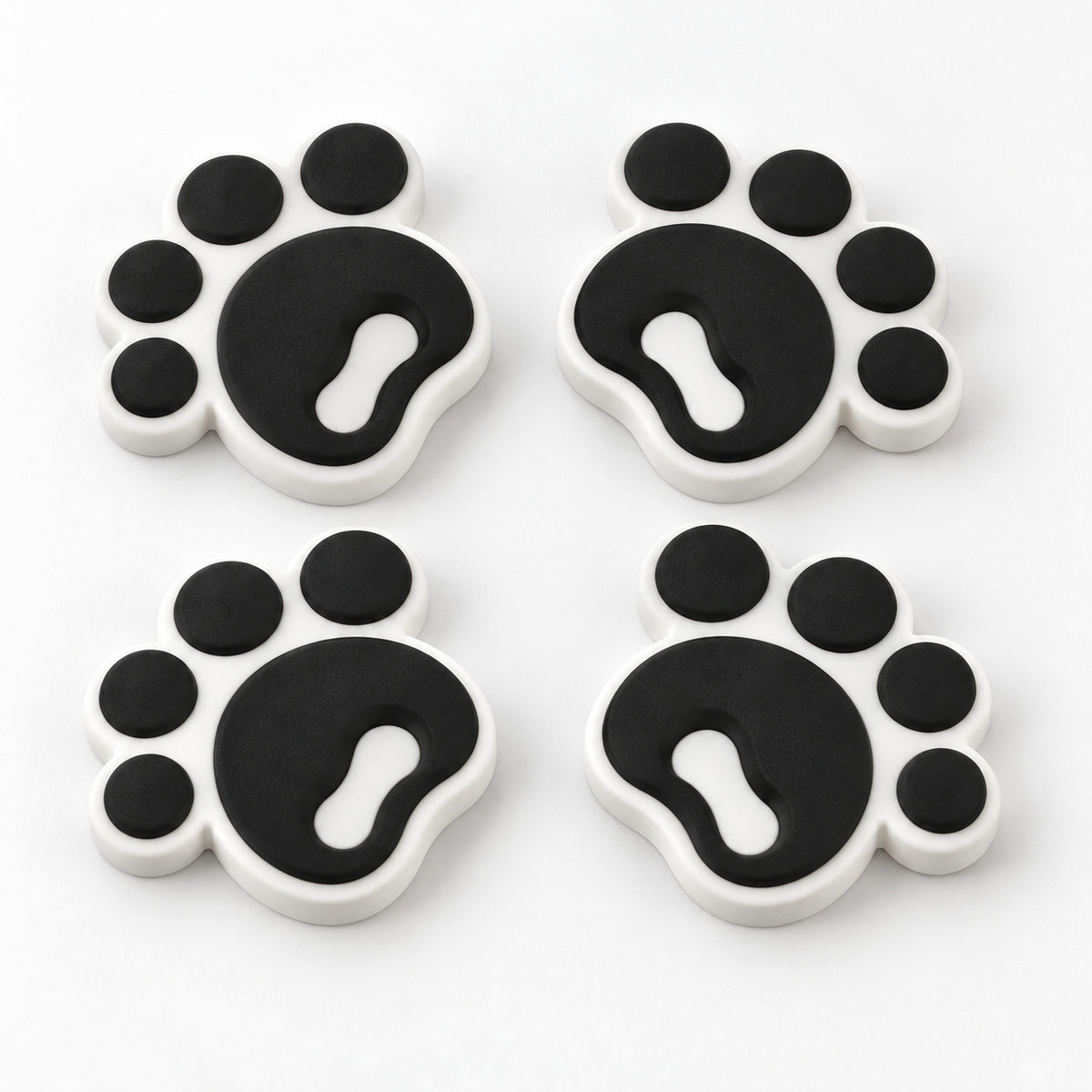 Four black pawprint snowboard stomp pads with white bases
