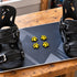 Four yellow pawprint stomp pads mounted between the bindings on a snowboard deck