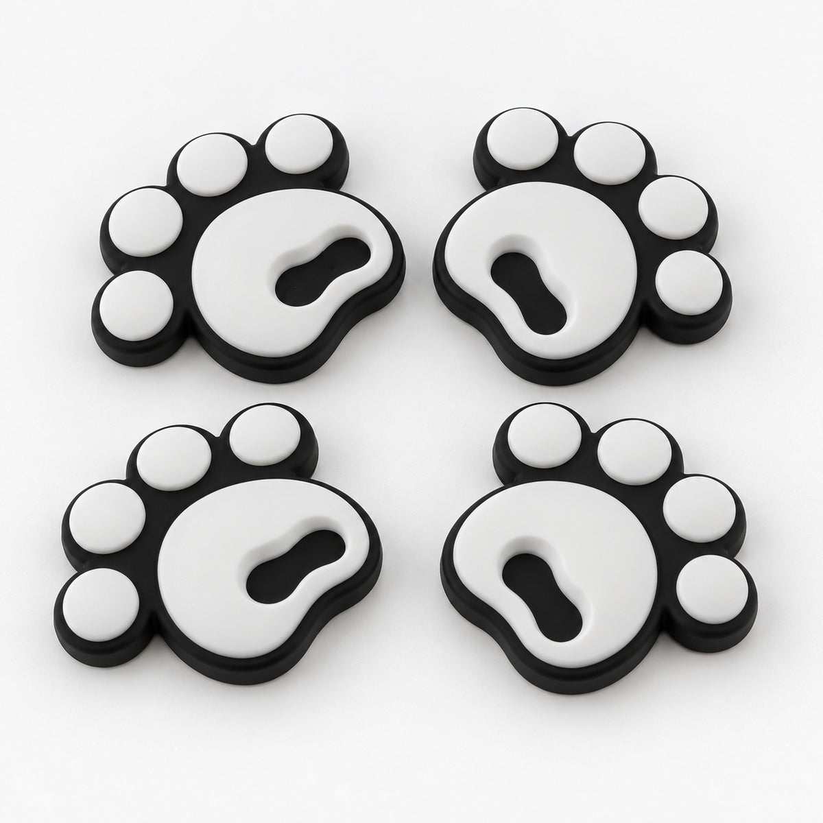 Four white pawprint snowboard stomp pads with black bases