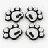 Four white pawprint snowboard stomp pads with black bases