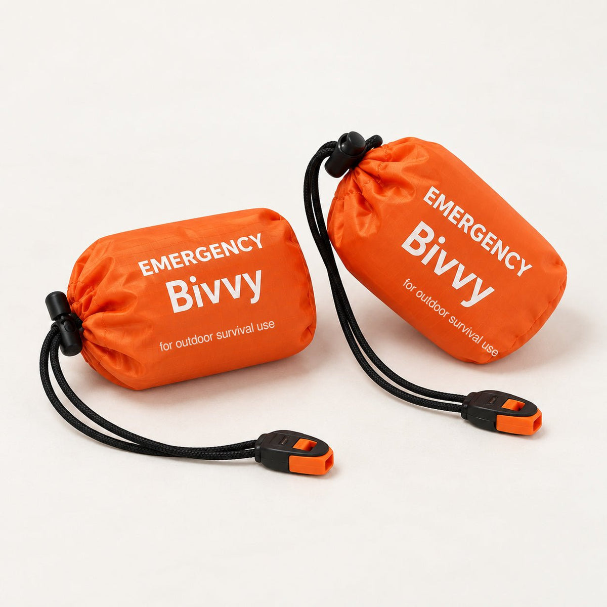 Two orange packed bivy covers in drawstring pouches with two orange-and-black whistles