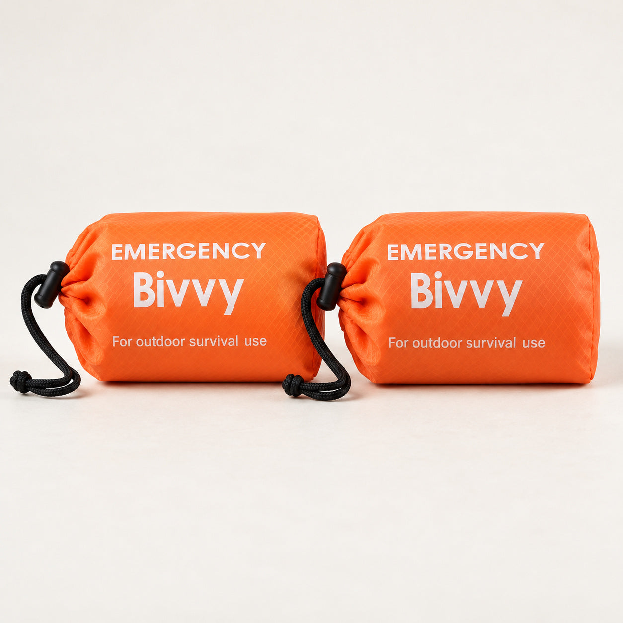 Two orange packed bivy covers in drawstring pouches without whistles
