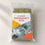 One folded olive-green bivy cover in a clear retail sleeve with a printed insert, without a drawstring pouch