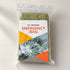 One folded olive-green bivy cover in a clear retail sleeve with a printed insert, without a drawstring pouch