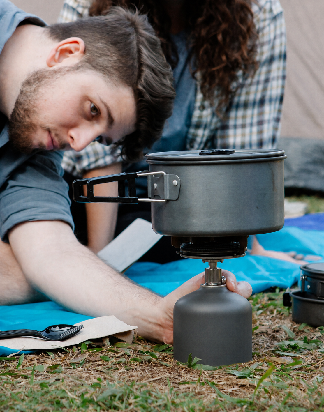 Camper preparing food on a compact camping stove