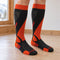 Grey and orange Bridgedale ski socks worn on two lower legs on a wooden floor.