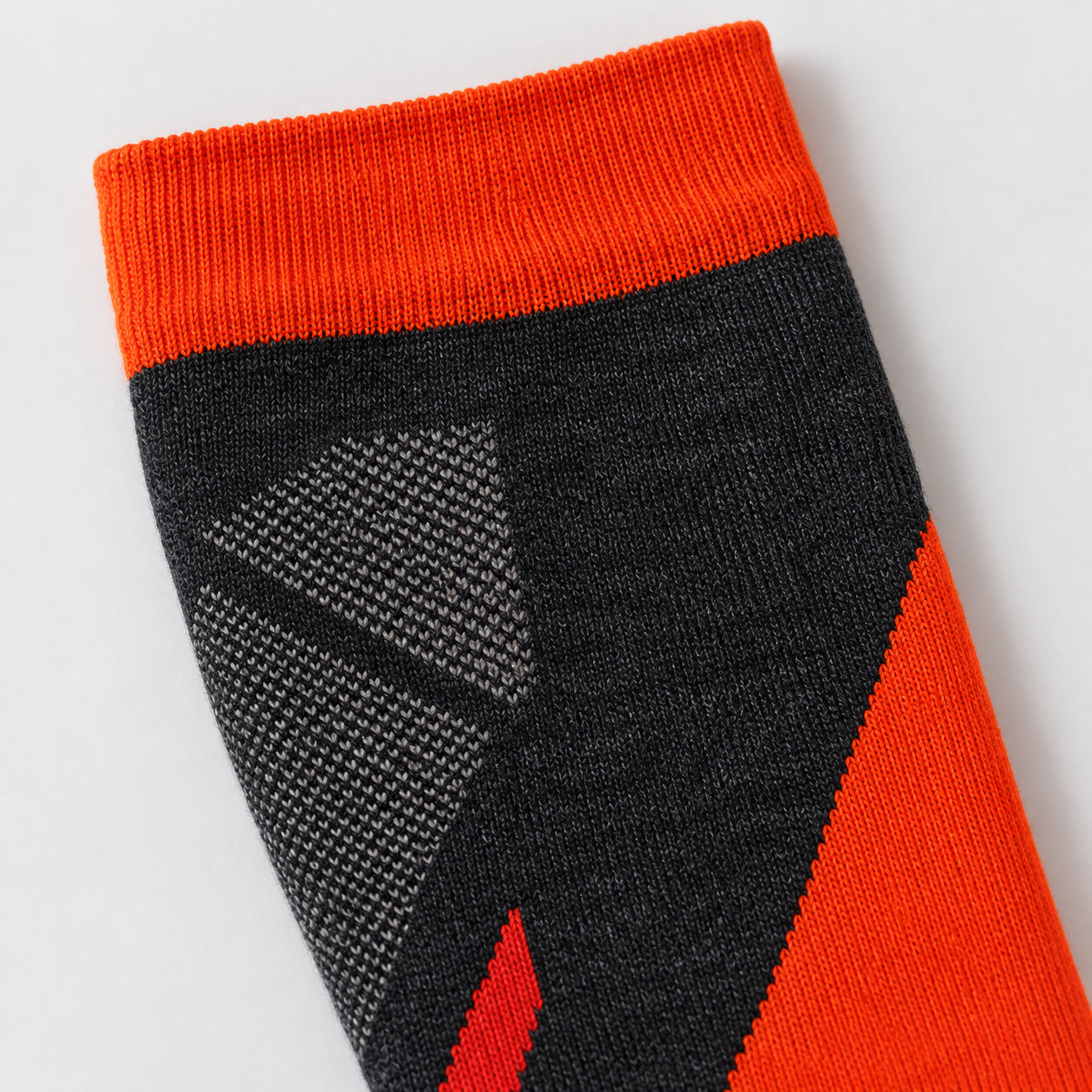 Close-up of the orange ribbed cuff and charcoal-and-gray shin knit on a Bridgedale Lightweight Alpine Ski sock.
