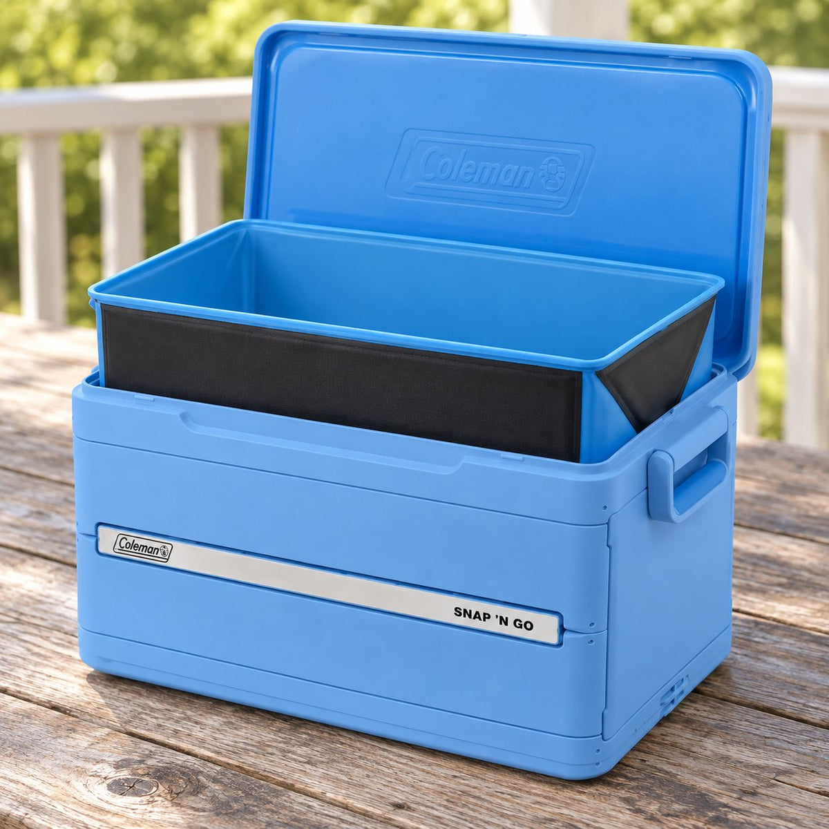 Open Blue Sky Coleman Snap ’N Go cooler with its blue-interior, dark-exterior liner partly raised on a porch table
