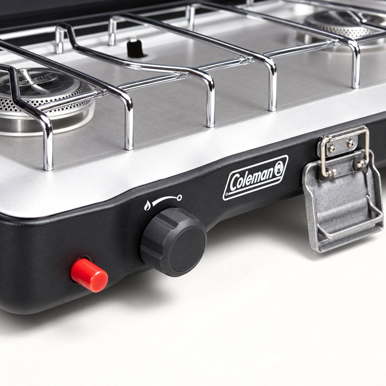 Close view of the Coleman Triton+ ignition button, burner control and carry-handle latch