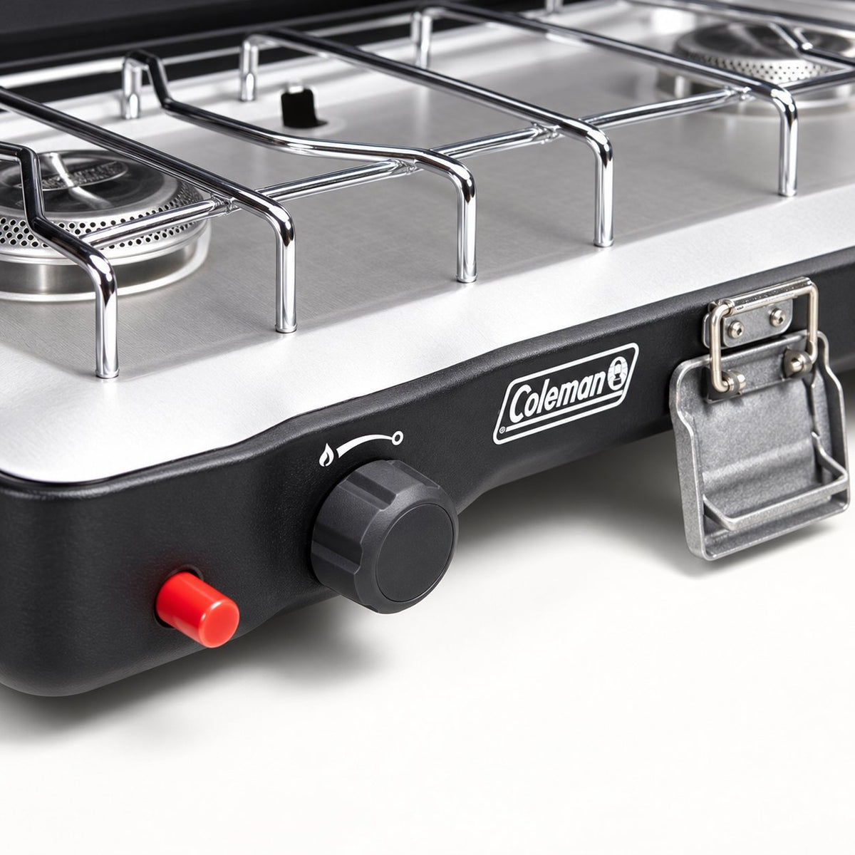Close view of the Coleman Triton+ ignition button, burner control and carry-handle latch