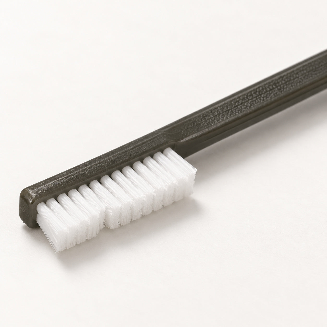 Close-up of the larger nylon-bristle head and textured Cypher X Brush handle