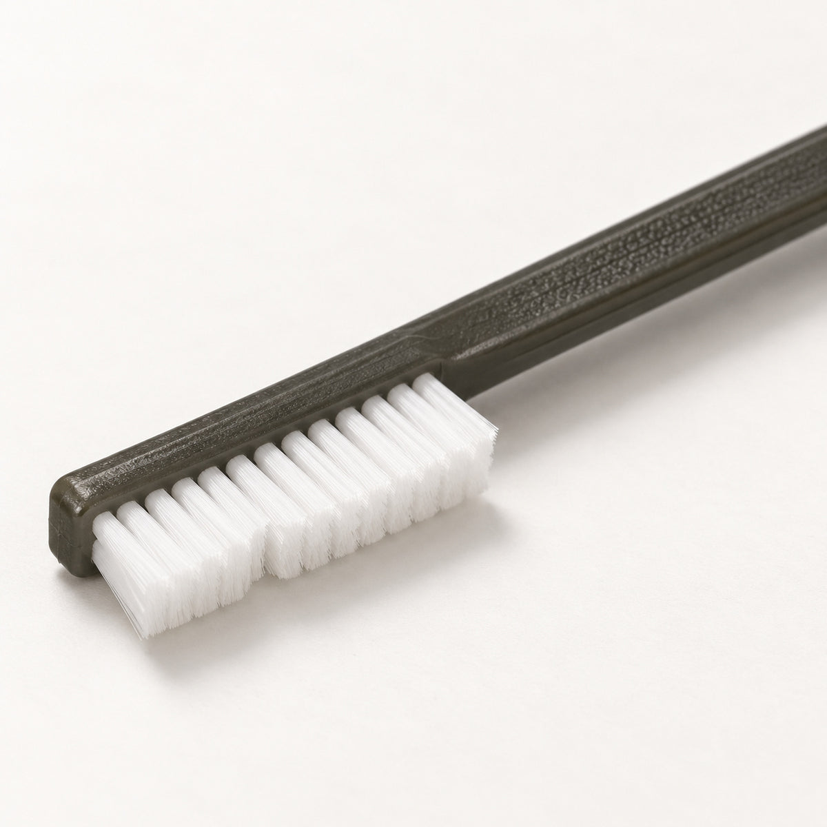 Close-up of the larger nylon-bristle head and textured Cypher X Brush handle