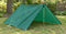 A green Equinox Egret nylon tarp in an open A-frame setup; support hardware shown for context.