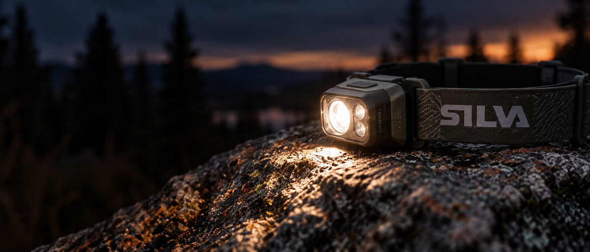 Illuminated Silva headlamp on a rock at blue hour