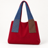 Burgundy colorblock shoulder tote with blue handles, blue pinstriped and brown front panels, and curved stitched front detail