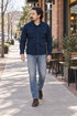 Man wearing the navy four-pocket shirt jacket on a neighborhood coffee-shop sidewalk.