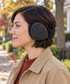 Adult wearing charcoal ear warmers with the band behind the head.