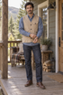 Man wearing the khaki cotton pocket vest over an indigo shirt on a porch.
