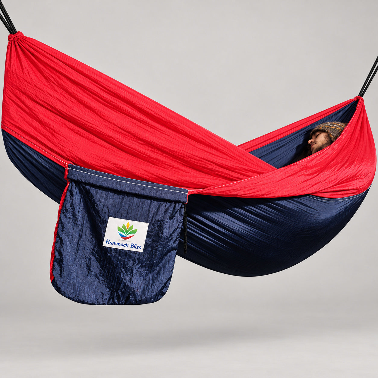 Hammock Bliss navy and red gathered-end hammock with its attached navy branded stuff sack.