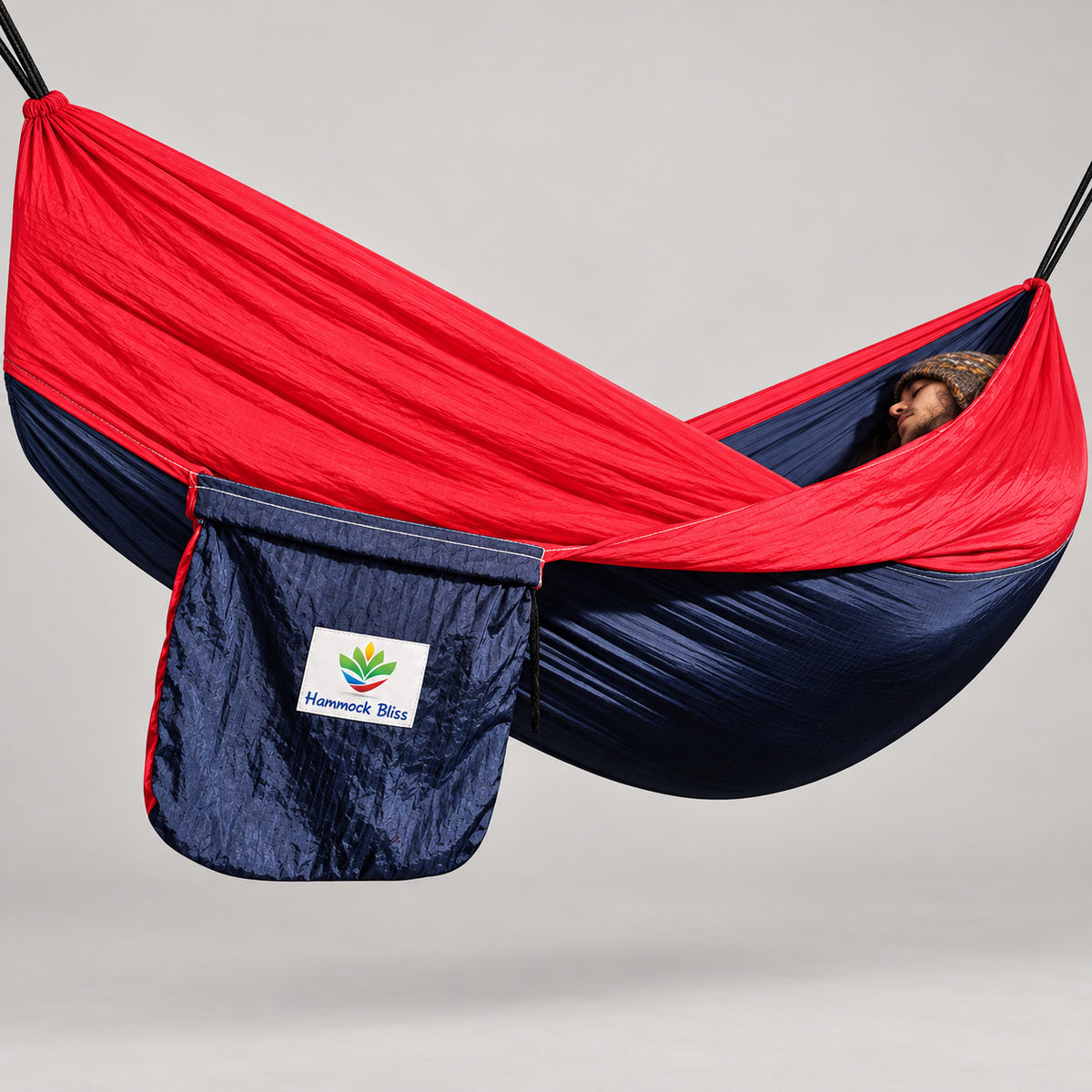 Hammock Bliss navy and red gathered-end hammock with its attached navy branded stuff sack.