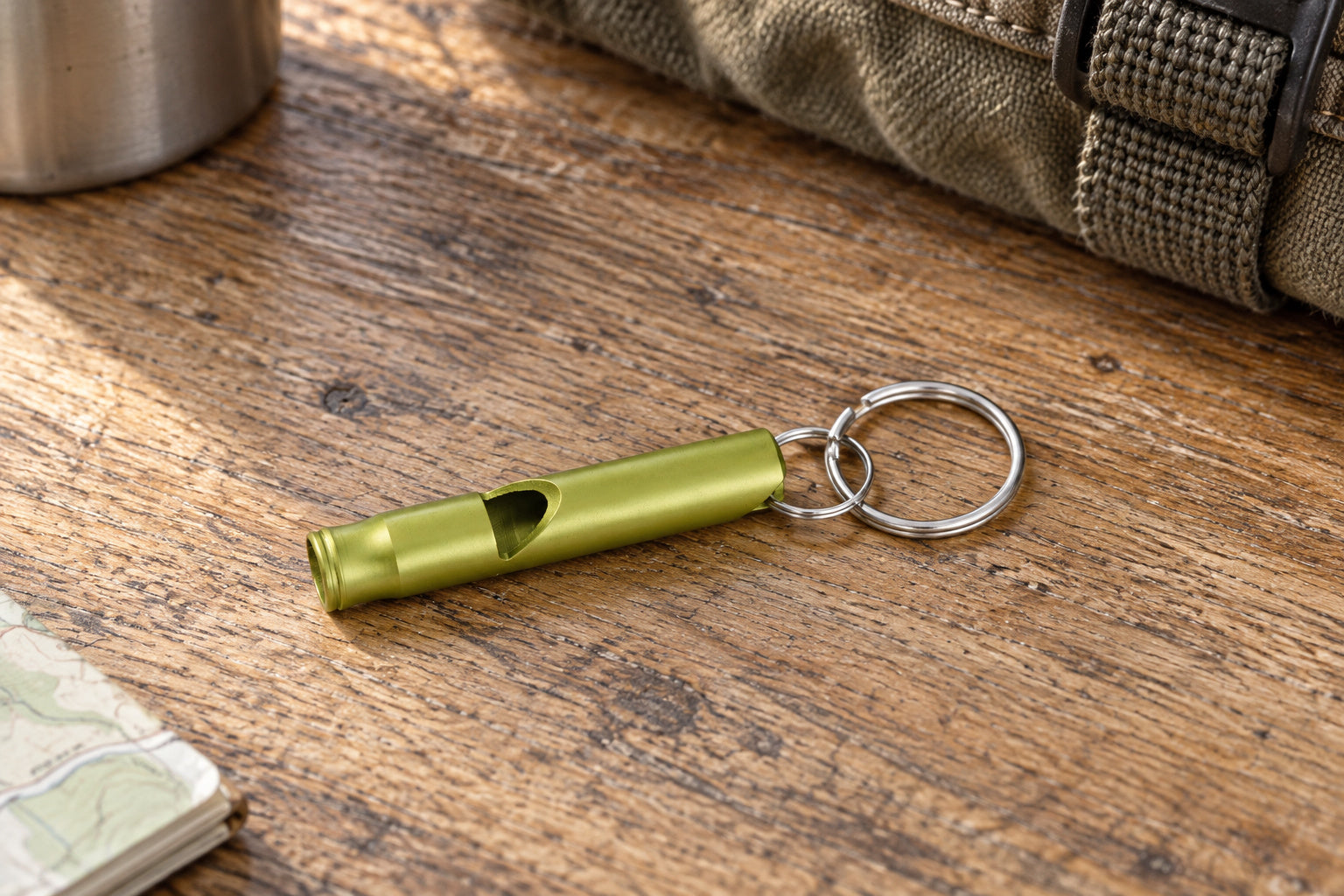 Munkees Small Aluminum Whistle resting on a home gear table