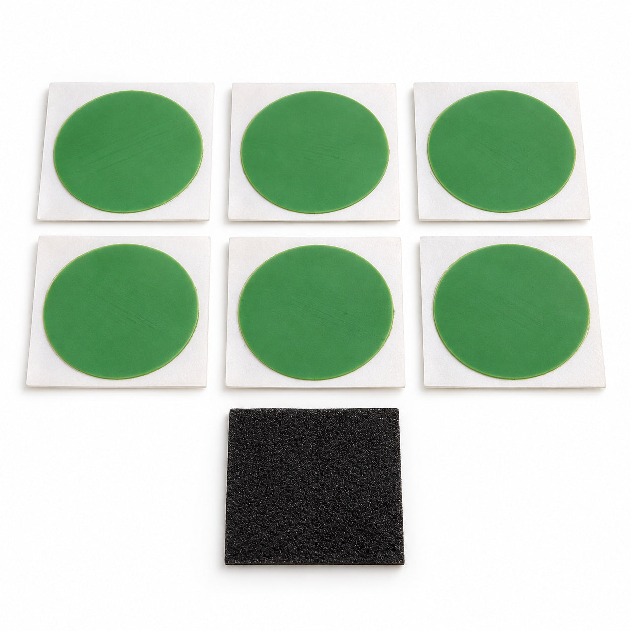 Six green Planet Bike SKAB patches on white backings with the included black abrading square