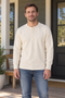 Man wearing the natural-colour Bronson three-button henley on a neighborhood porch.