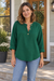 Woman wearing the dark green BOXDAQ three-button pullover with turned-up sleeves.