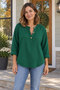 Woman wearing the dark green BOXDAQ three-button pullover with turned-up sleeves.
