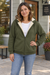 Woman wearing a army green fleece-lined zip hoodie outside a neighborhood coffee shop.