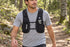 Gray 500 mL soft flask seated in the front pocket of a black running vest during a woodland trail walk.