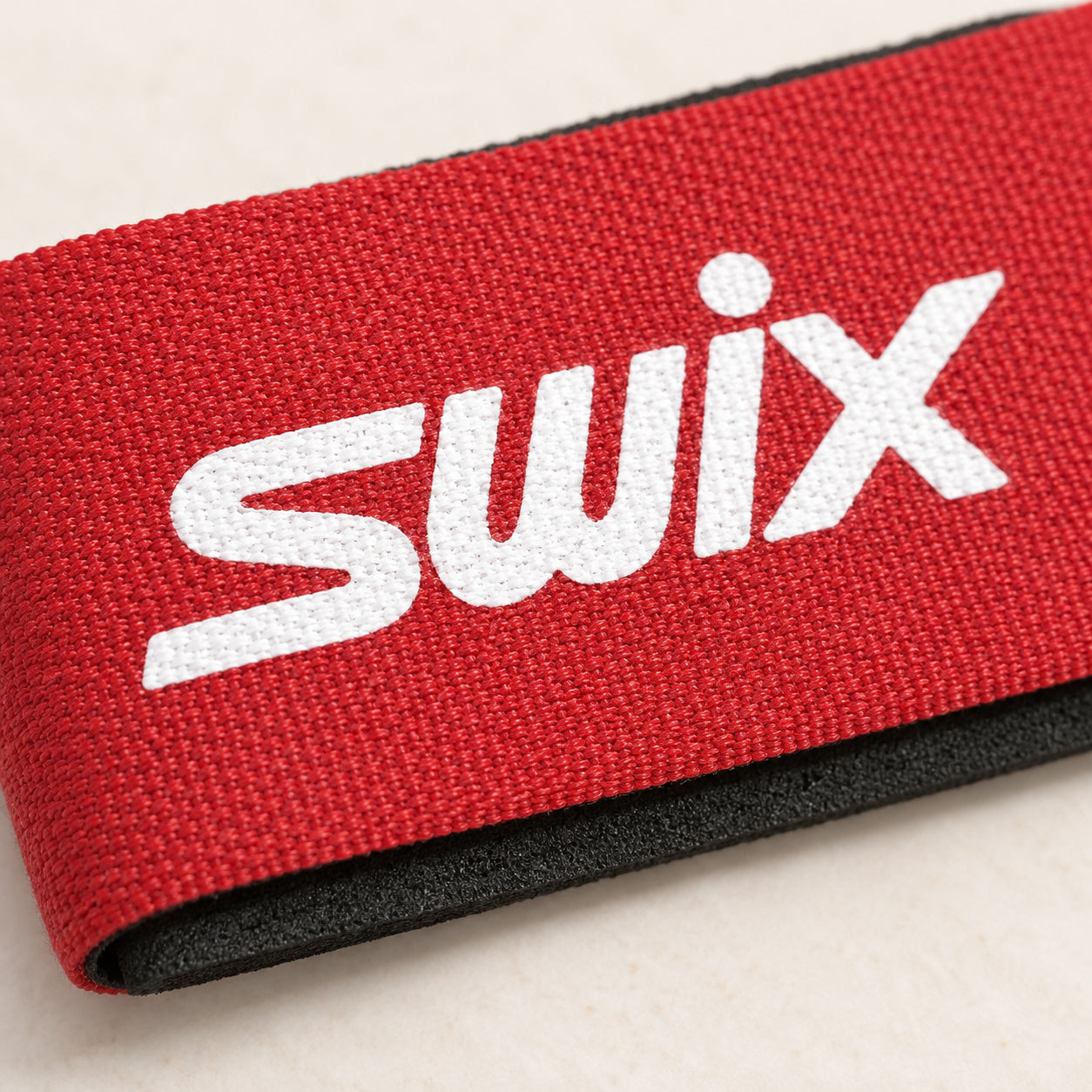 Close-up of Swix strap fabric, white branding and the black protector edge