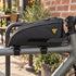 Black Topeak TopLoader bag mounted on a bicycle top tube outside a neighborhood cafe