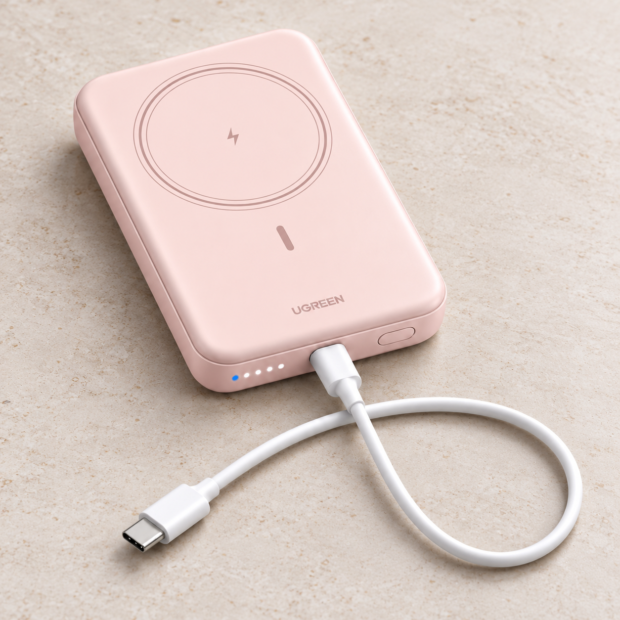 Pink UGREEN PB561 magnetic power bank in a front studio view