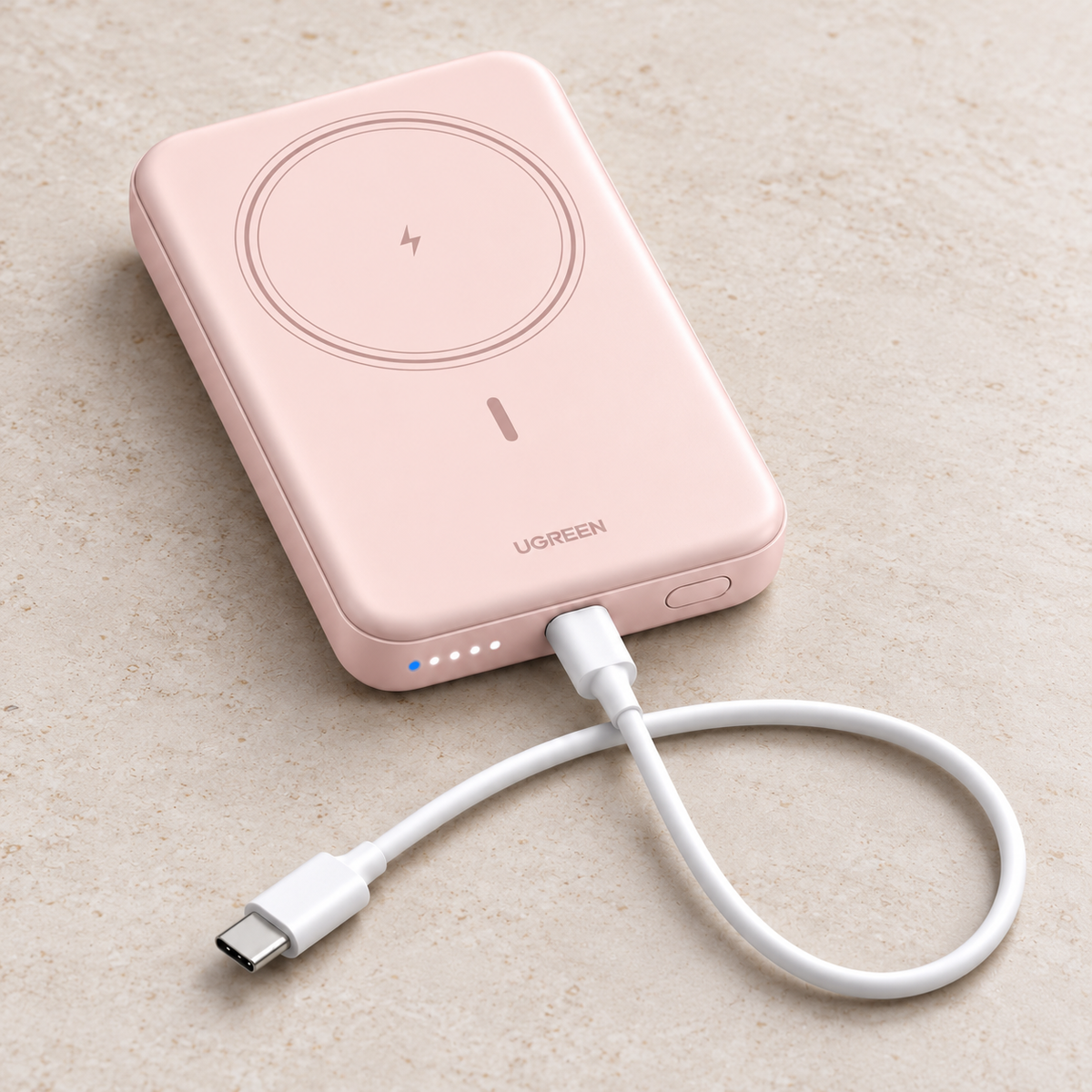 Pink UGREEN PB561 magnetic power bank in a front studio view