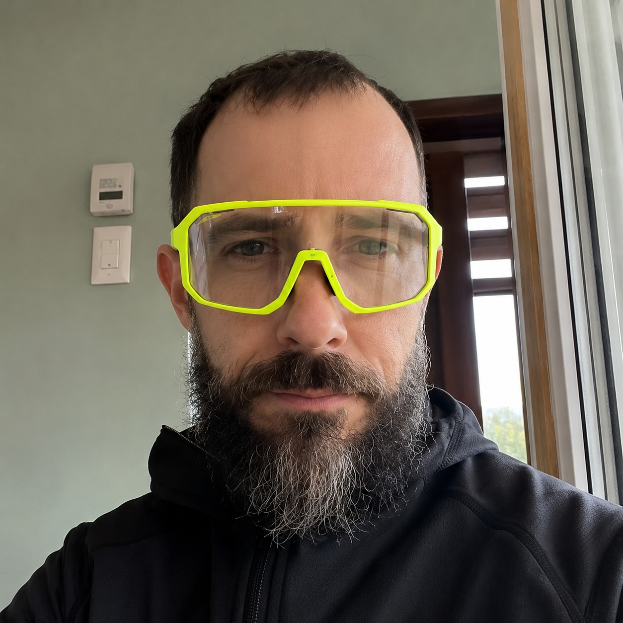 Indoor low-light selfie wearing High-Vis Yellow ApexShift clear-to-dark cycling glasses