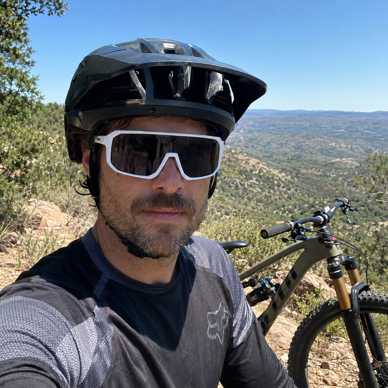 Mountain biker wearing White ApexShift clear-to-dark cycling glasses
